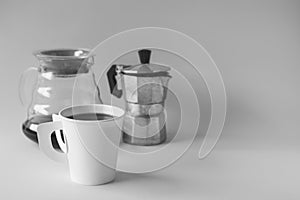Hot coffee in a mug and jug and percolator classic boiler Italian Moka coffee pot on paper background