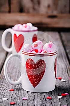 Hot coffee with pink marshmallow in mugs with hearts for Valentine day