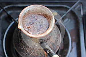 Hot coffee prepared in turk on gas. Closeup