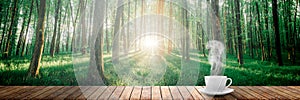 A hot coffee on the table on a spring forest background