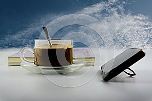 Hot coffee, tea cup on transparent saucer, slow motion, hot transparent glass coffee cup, with book on white back table, in nature