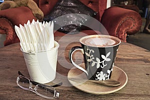 Hot coffee with tissue paper coffee on wooden table