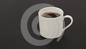 Hot coffee in white mug isolated on black background