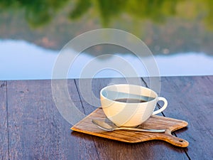 Hot coffee on wooden saucer and on wooden table