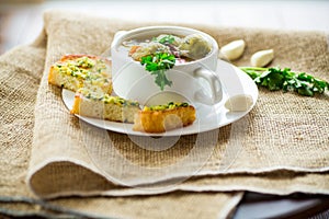 Hot cooked soup with Brussels sprouts, vegetables and croutons, in a plate.