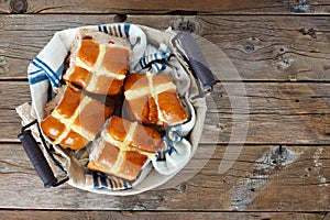 Hot Cross Buns in a basket, over rustic wood