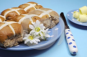 Hot Cross buns with butter curls on blue background - close-up