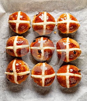 Hot cross buns,freshly baked hot cross buns on white parchment paper, top view.