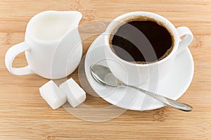 Hot cup of coffee, jug milk, spoon and sugar