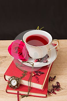 Hot cup of red tea and books