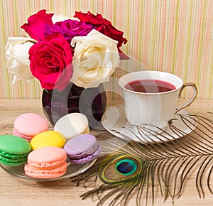 Hot cup of red tea and colored cakes