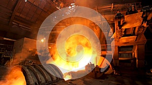 Hot dark workshop of steel production in electric furnaces, with burning fire and smoke. Stock footage. Metallurgical