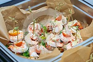 Hot Delicates, appetizer canape with tiger shrimp, fused cheese and vegetables. Catering service.