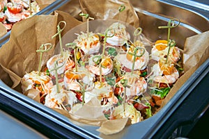 Hot Delicates, appetizer canape with tiger shrimp, fused cheese and vegetables. Catering service.