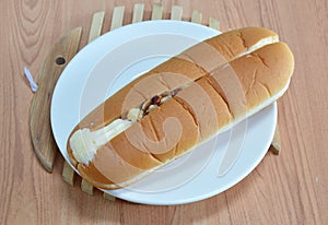 Hot dog bread filled cream and almond on wooden dish plate