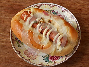 Hot dog bun garnished with cheese and sauerkraut