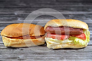 hot dog in buns with thousand island dressing sauce of ketchup mayonnaise, grilled beef sausage, tomato, lettuce