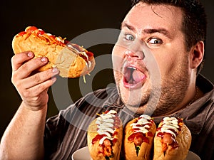 Hot dog contest. Fat man eating fast food hot dog.