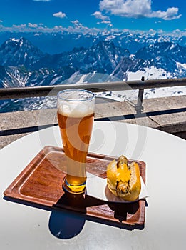 Hot dog with german beer with view of alps mountain range