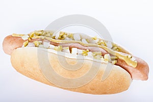 Hot dog grill with mustard, onion and pickles isolated on white