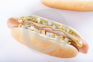 Hot dog grill with mustard, onion and pickles isolated on white