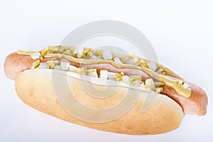 Hot dog grill with mustard, onion and pickles on white