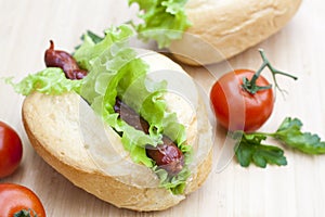 Hot dog. Grilled hot dogs with fresh salad lettuce on wooden table.