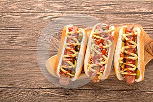 Hot dog with grilled sausage  mustard  and ketchup  onions  and greens on paper background