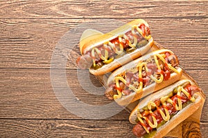 Hot dog with grilled sausage  mustard  and ketchup  onions  and greens on paper background