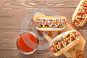 Hot dog with grilled sausage  mustard  and ketchup  onions  and greens on paper background