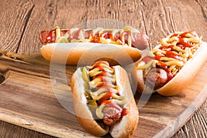 Hot dog with grilled sausage  mustard  and ketchup  onions  and greens on paper background