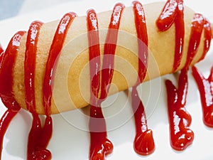 Hot dog with ketchup on a white plate