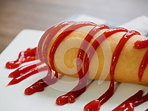 Hot dog with ketchup on a white plate