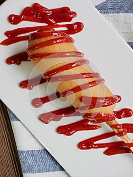 Hot dog with ketchup on a white plate