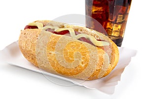 Hot-dog with mustard and ketchup in the tray with cola on white