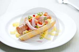 hot dog with relish and onions on white plate