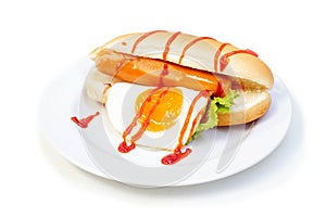 Hot Dog sausage, fried egg and vegetables with tomato sauce in white plate