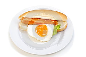 Hot Dog sausage, fried egg and vegetables in white plate