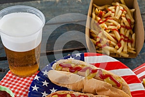 Hot dog served on plate with french fries and beer
