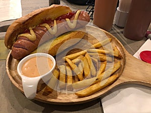 Hot Dog With Yellow Mustard, Sauce and French Fries, serving on wood tray. ready to eat. Fast food concept