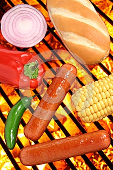 Hot dogs, bun and veggies on a barbecue grill