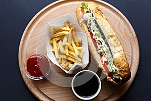 Hot Dogs with French fries and ketchup on wooden plate photo