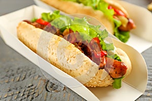 Hot dogs on grey wooden table, closeup. Fast food