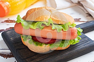 Hot dogs on a wooden Board. Hot dog with lettuce tomato and sausage. Copy space.