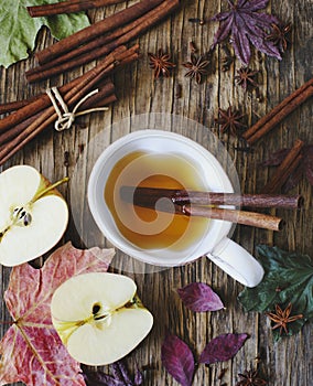 Hot drink apple tea, sider, punch with cinnamon stick, star anise and clove. Seasonal mulled drink on wooden background.