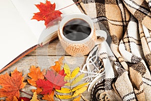 Hot drink in a large cup, book, colorful autumn leaves