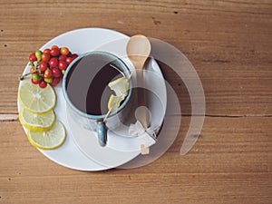 hot drink with lemon on wooden table in autumn