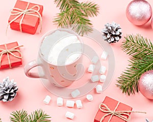 Hot drink with marshmallows close up. Christmas background with fir branches, lights, presents, pink decorations on pink