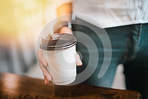 Hot drink in paper cup in hands close up