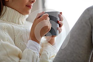 Girl with tea mug sitting at home window